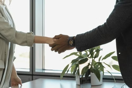 Dos personas dándose la mano en un entorno de oficina